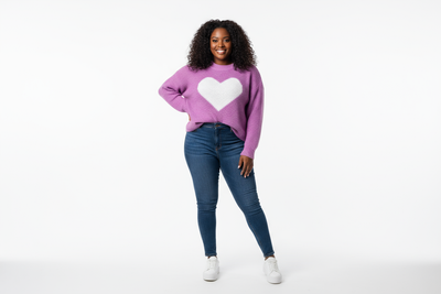 Plus size black model woman wearing a purple sweater with a heart logo in the middle full body image and background should be white tinted